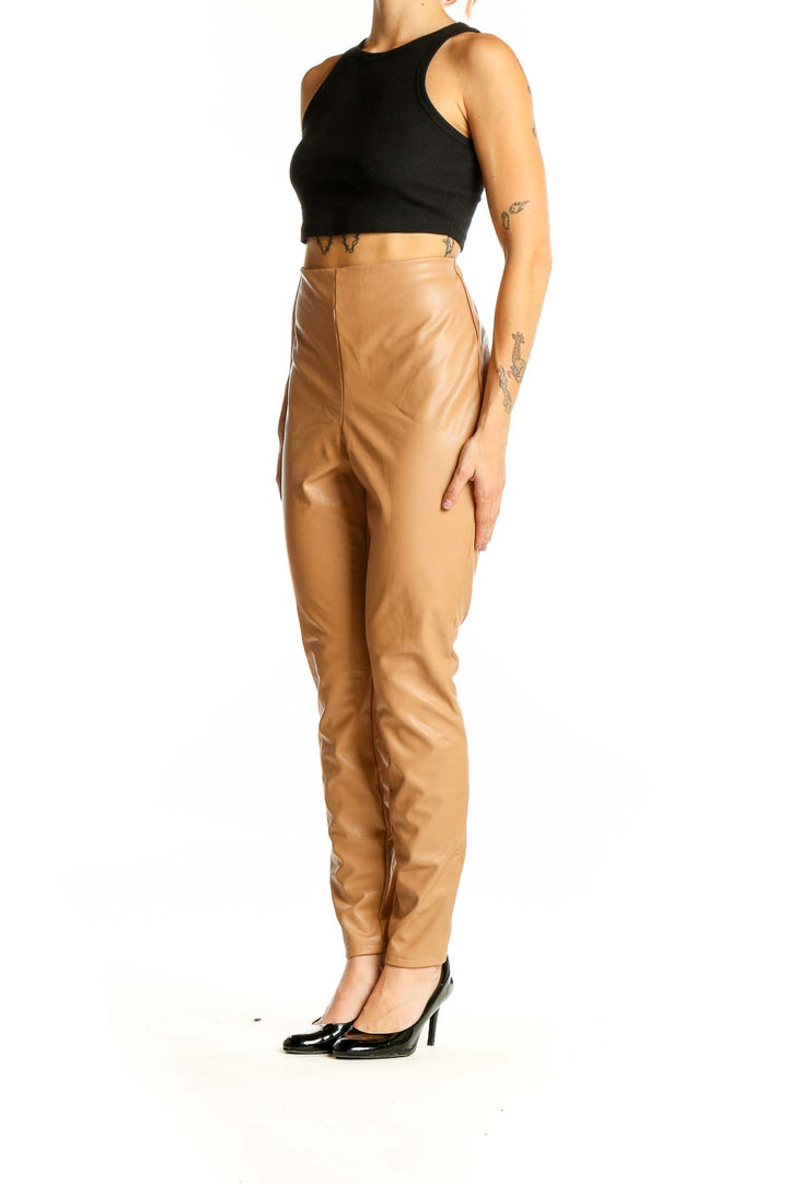 Front view of tan high-waisted faux leather pants from Express