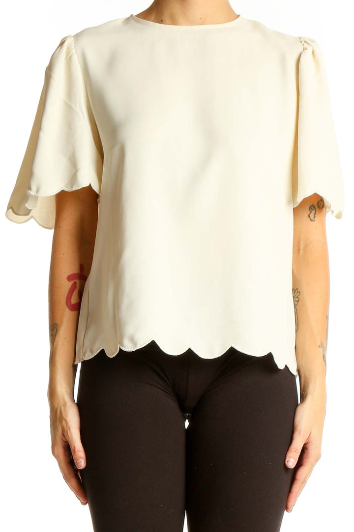 Front view of Express cream blouse with scalloped hem and short sleeves