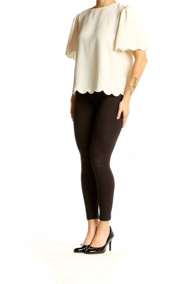 Front view of Express cream blouse with scalloped hem and short sleeves