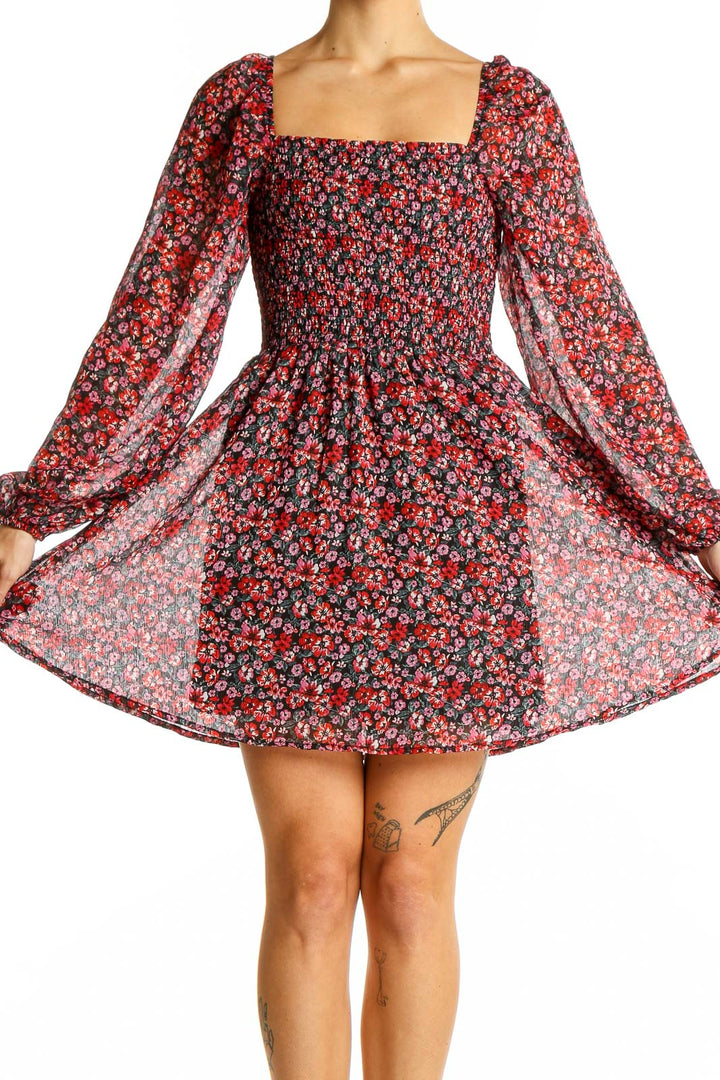 Front view of Francesca's red floral smocked mini dress with square neckline and long sleeves