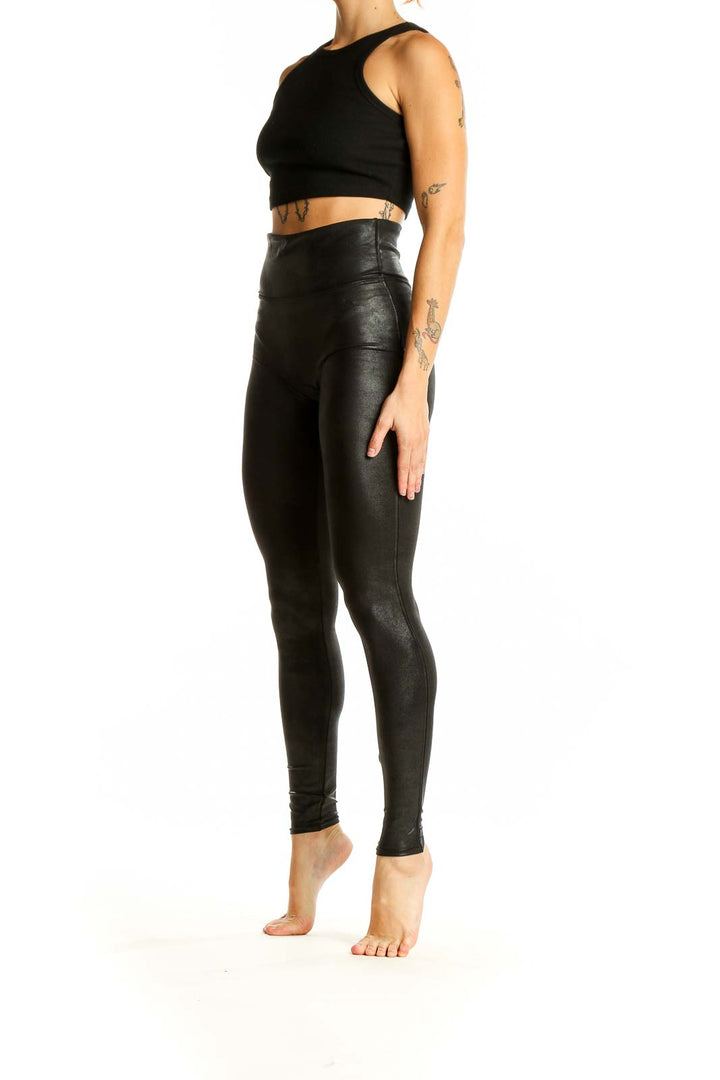 Front view of Spanx black faux leather high-waisted leggings on model