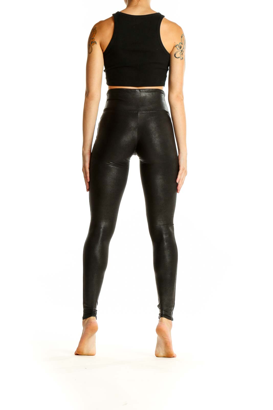 Side view of Spanx black faux leather high-waisted leggings on model with black crop top