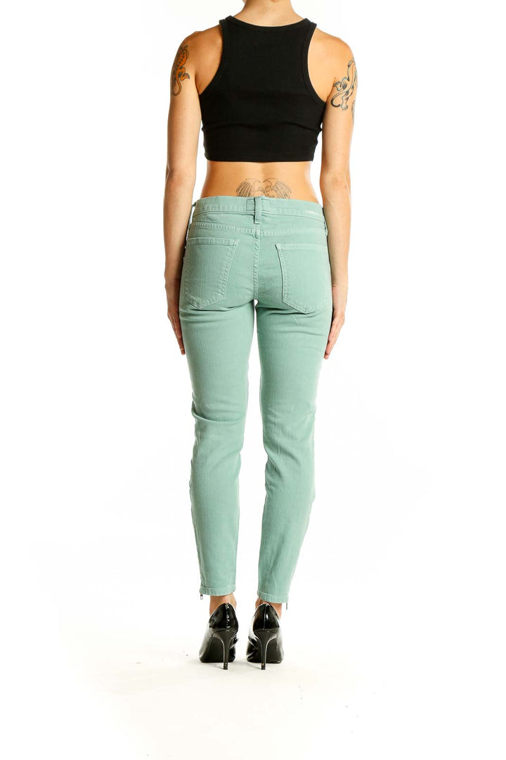 Side view of model wearing Current/Elliott mint green skinny ankle jeans