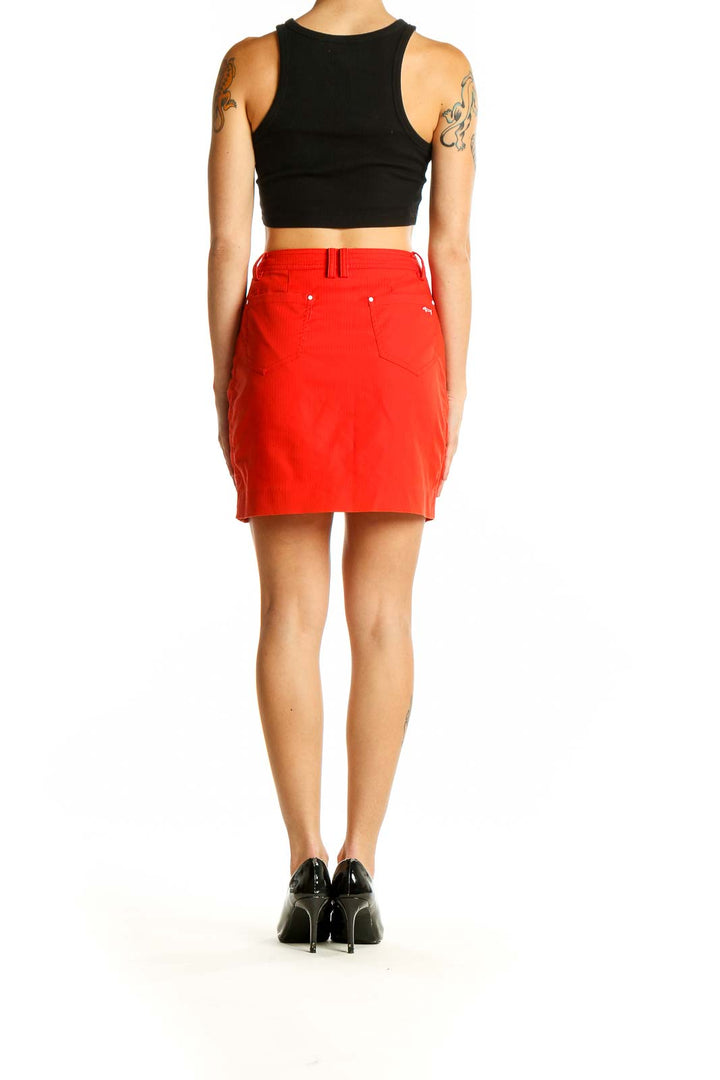 Side view of Louis Castel red mini skirt on model with black top