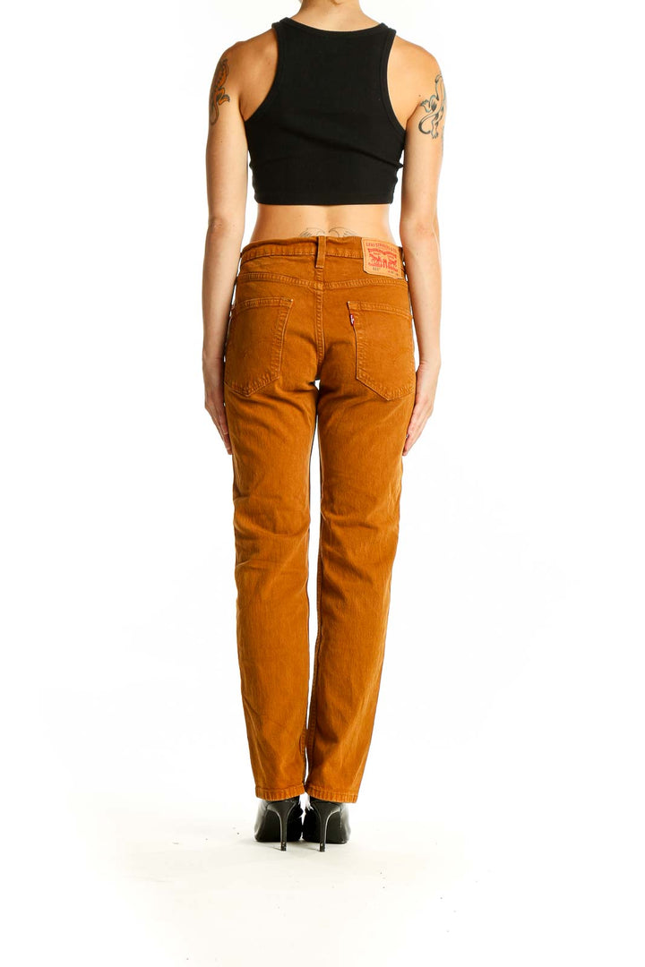 Side view of Levi's rust orange straight leg jeans on model