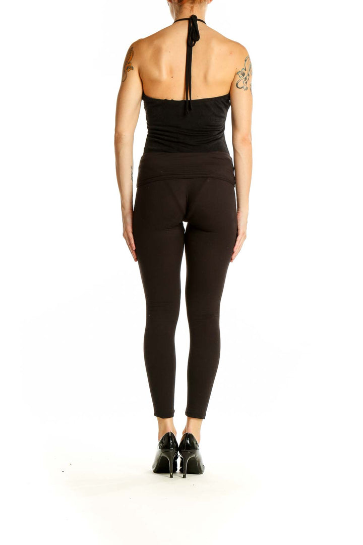 Side view of woman wearing Lulu's black halter neck bodysuit with fitted pants