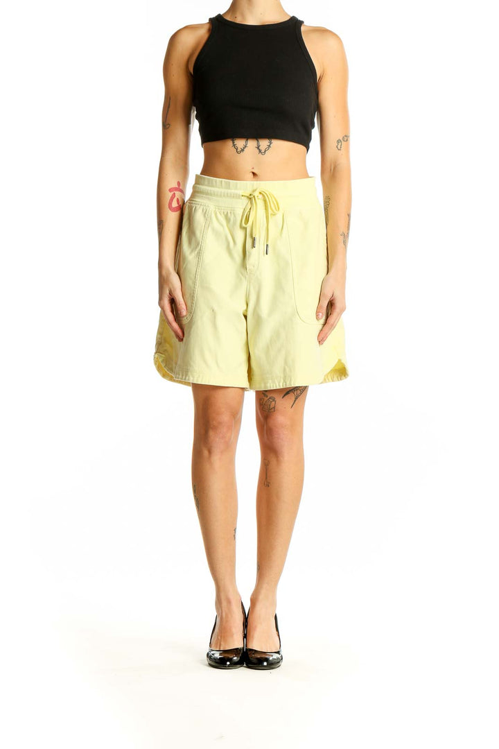 Front view of yellow Callaway drawstring shorts with side pockets