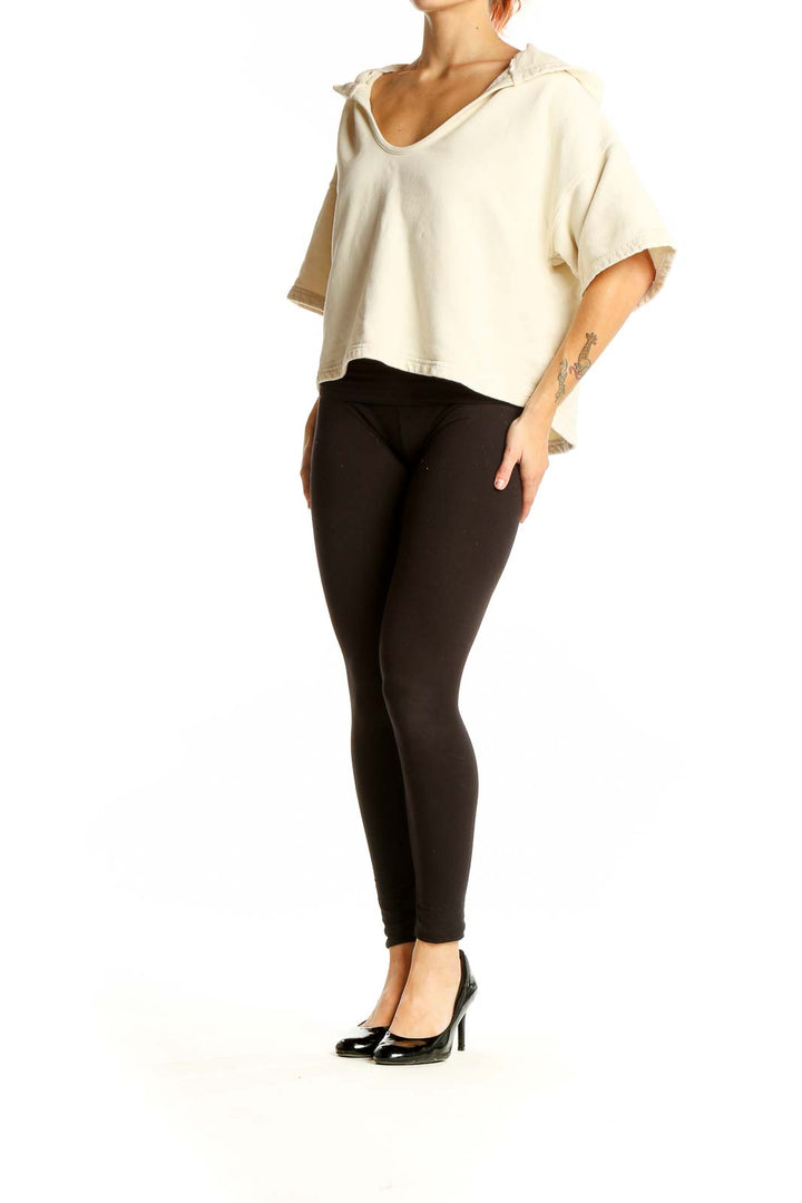 Front view of Joie cream cropped hooded knit top on model