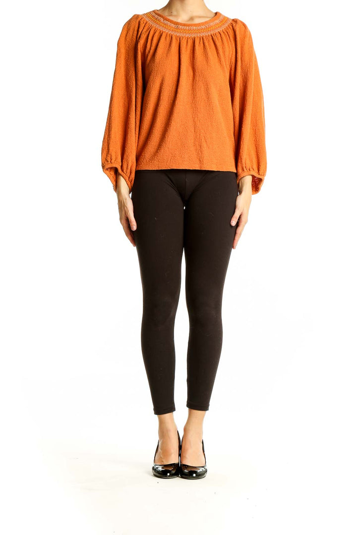 Front view of orange Madewell cotton knit peasant top with gathered neckline