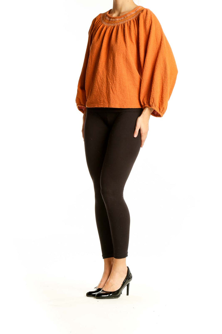 Front view of orange Madewell cotton knit peasant top with gathered neckline