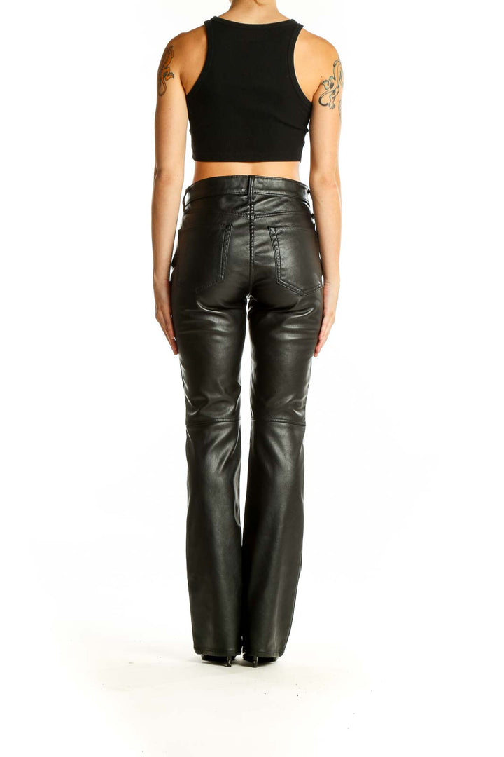 Back view of Gap black faux leather flare pants on model