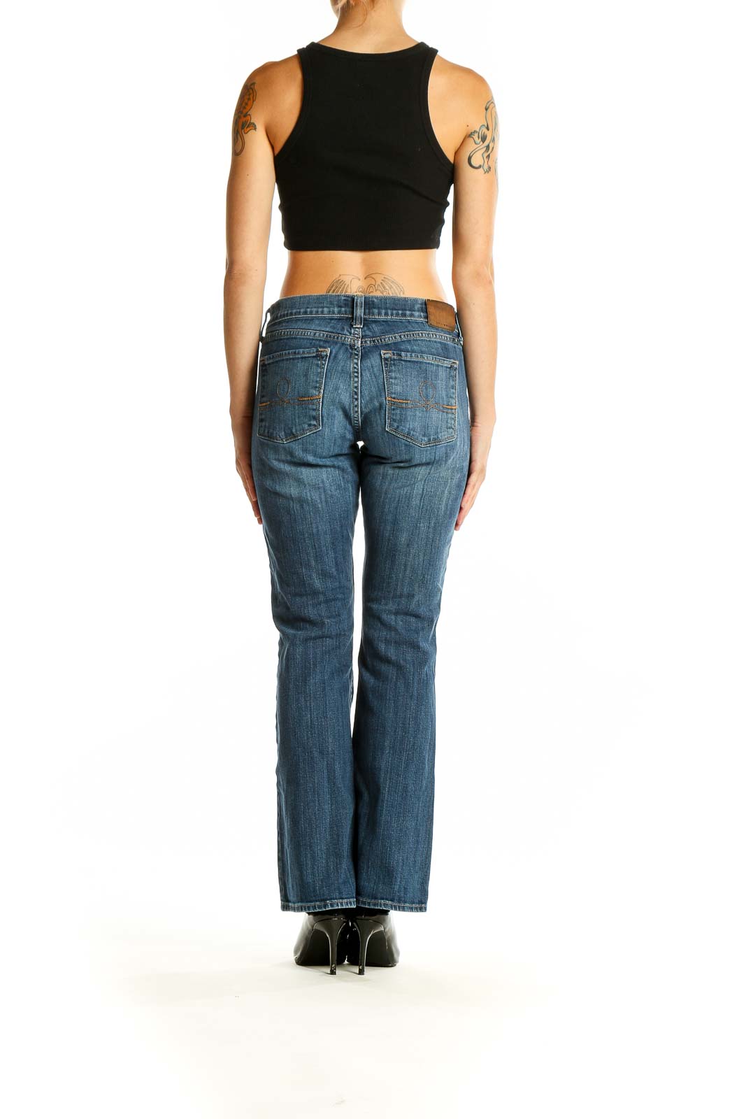 Side view of Lucky Brand blue bootcut jeans on woman with black top