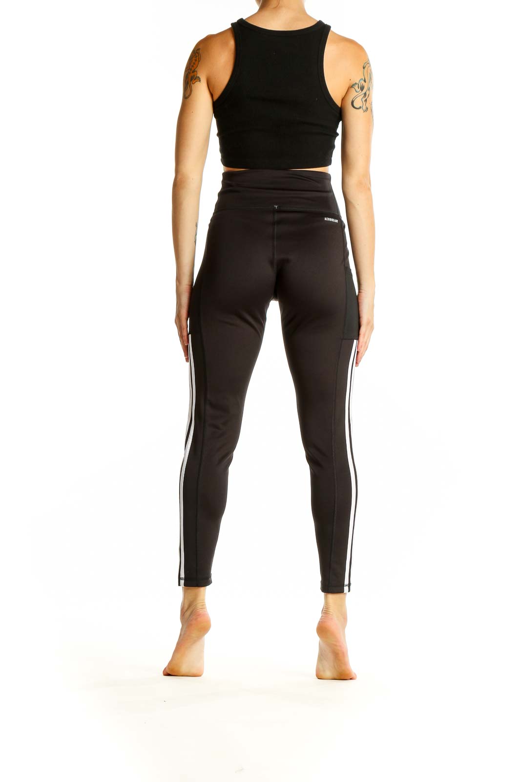 Side view of woman wearing black Adidas high-waisted leggings and crop top