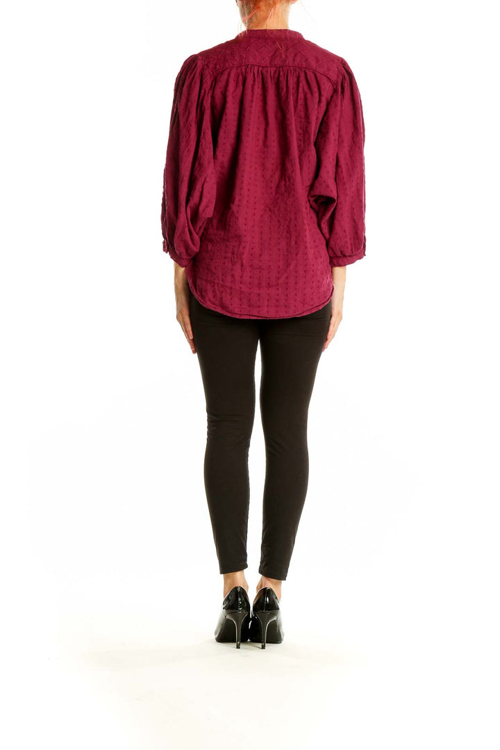 Back view of burgundy textured cotton blouse showing relaxed fit and gathered sleeves