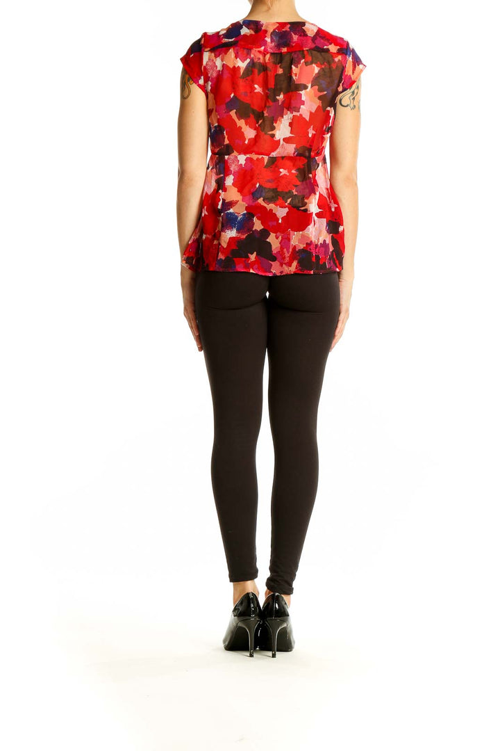 Back view of Banana Republic red floral print wrap-style blouse on model with black pants