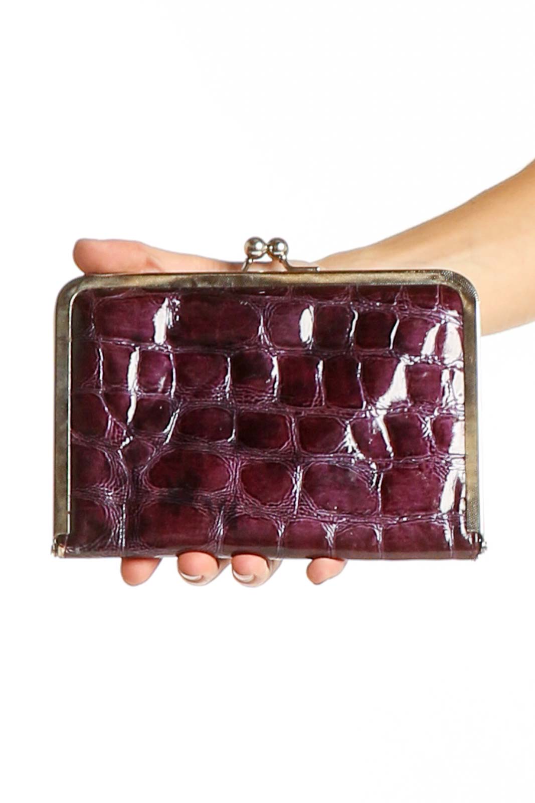 Front view of burgundy croc-embossed leather clutch with gold-tone frame closure