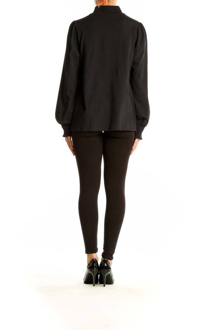 Side view of J.Jill black long-sleeve top showing puffed sleeves and relaxed fit