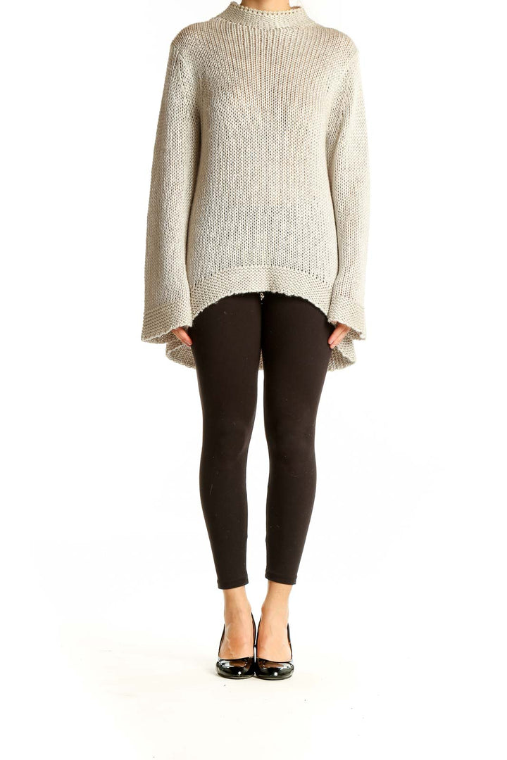 Front view of Stella Carakasi beige oversized chunky knit sweater with high-low hem