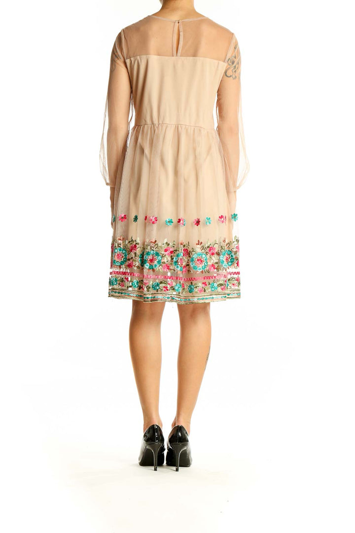 Back view of Entro beige dress showing floral embroidered hem