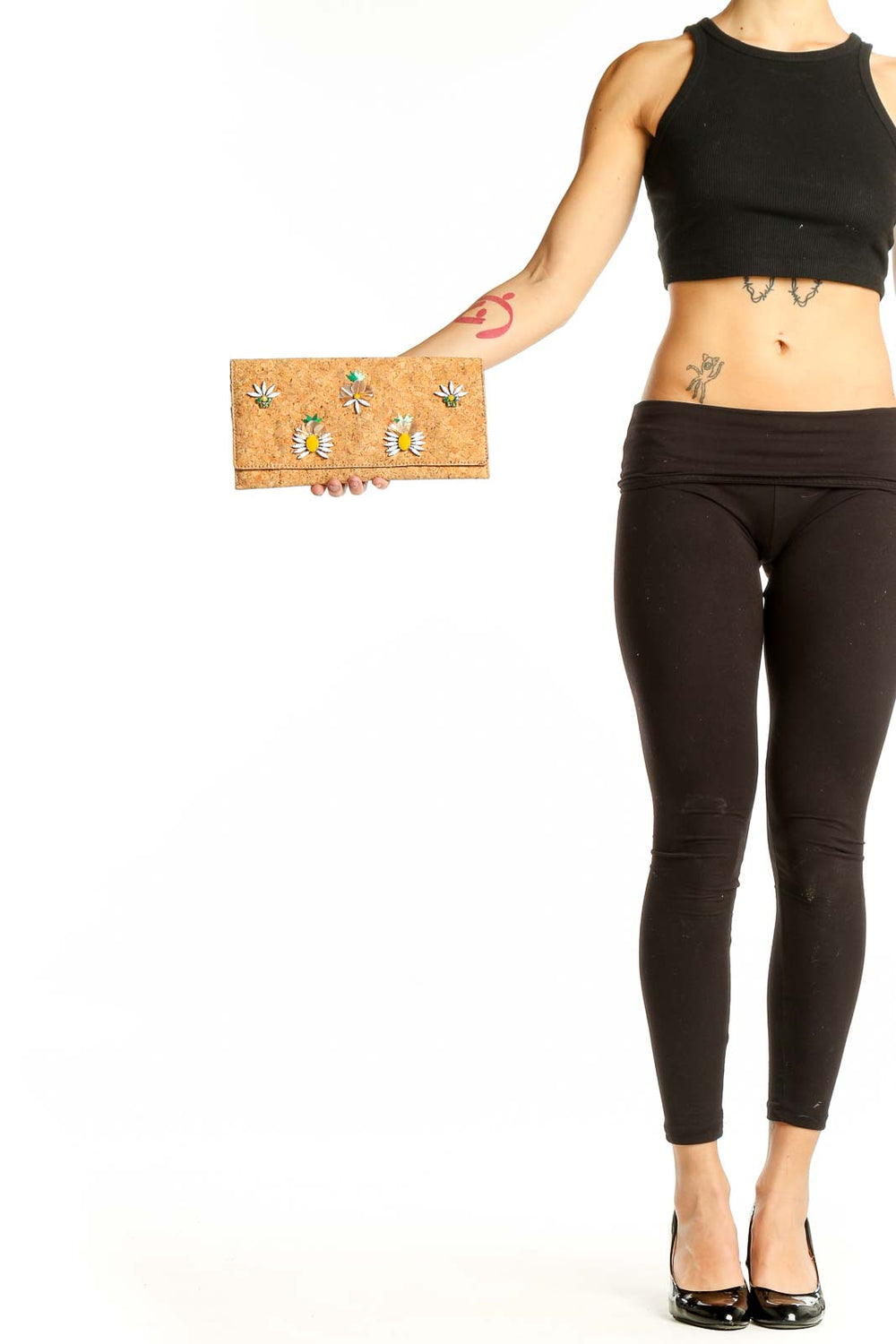 Cork clutch with colorful floral embellishments held in hand