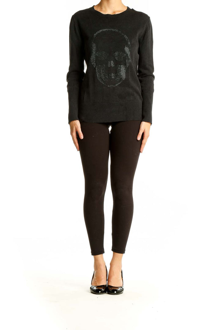 Front view of black knit sweater with studded skull design