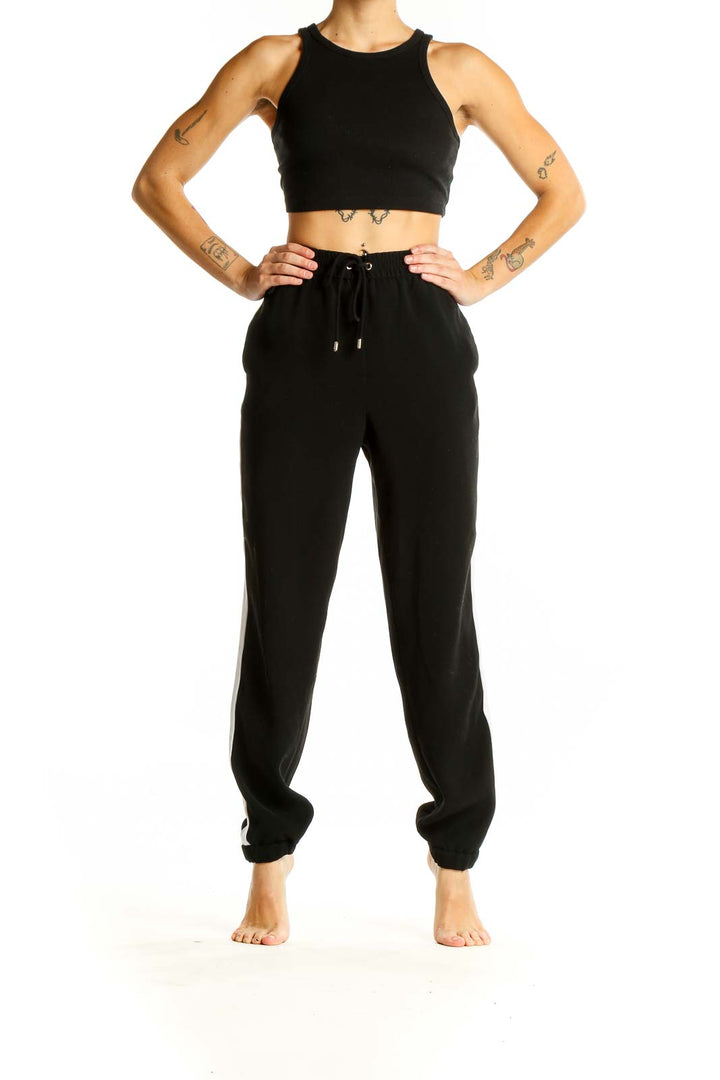 Front view of black MICHAEL Michael Kors jogger pants with white side stripe