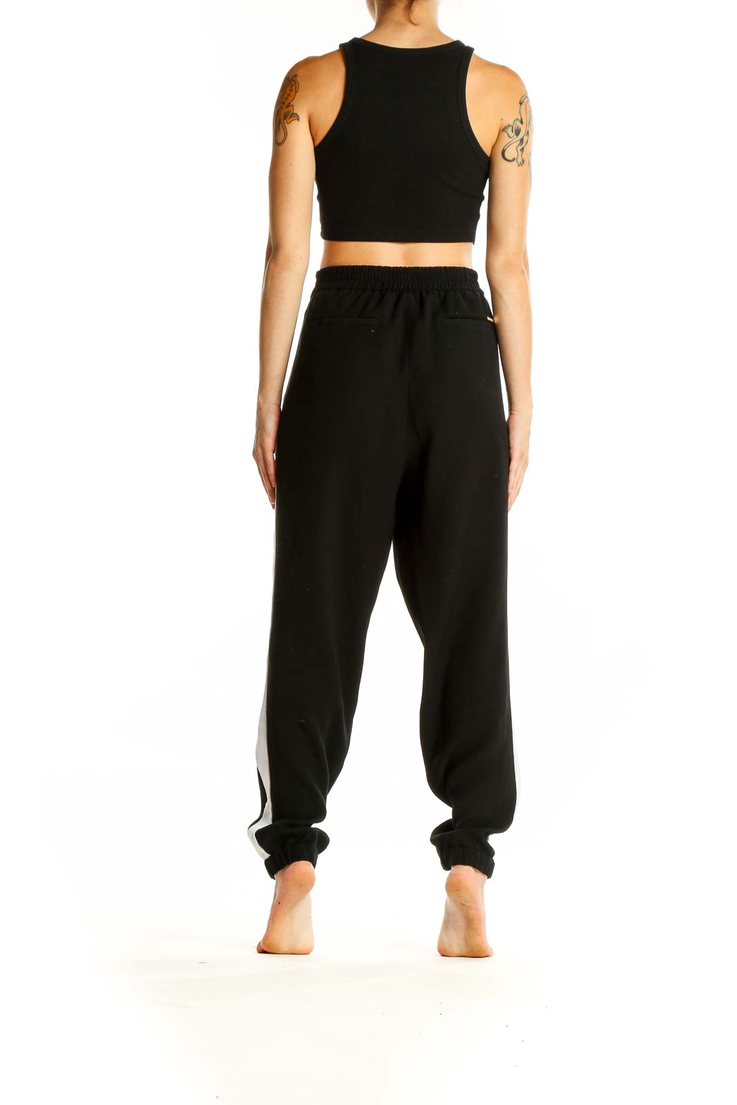 Side view of woman wearing black MICHAEL Michael Kors jogger pants with white stripe