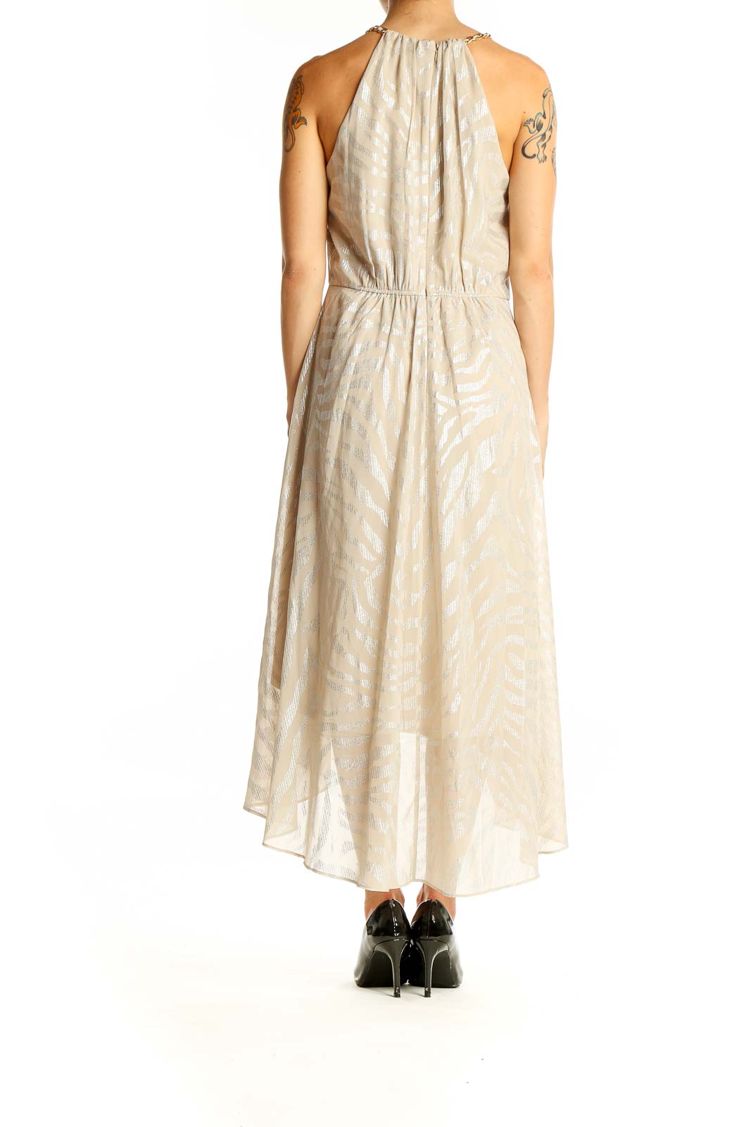 Back view of beige metallic halter neck midi dress with gathered detail