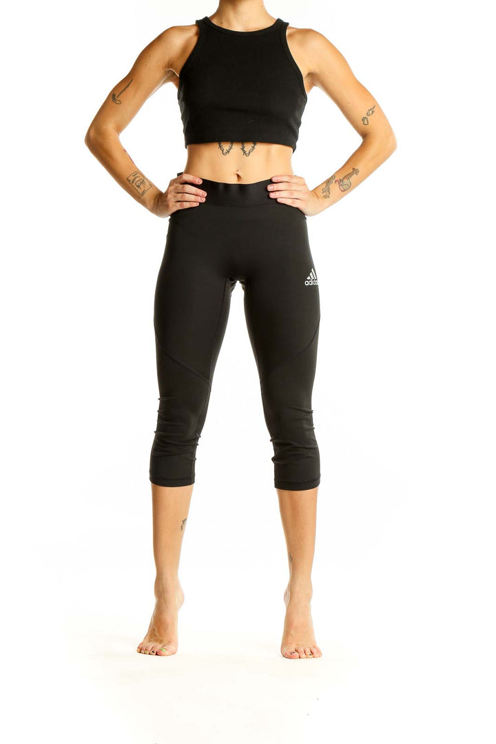 Front view of black Adidas capri leggings on model