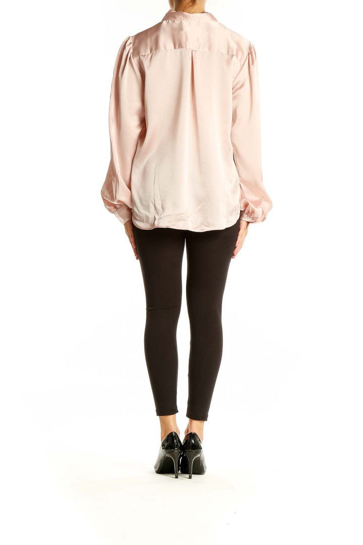 Back view of blush pink satin blouse showing relaxed fit and long sleeves