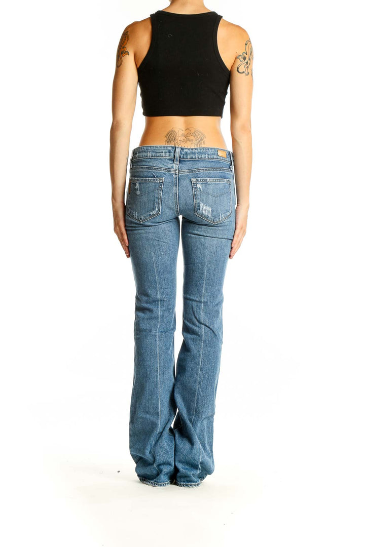 Back view of Paige light blue distressed flare jeans on model