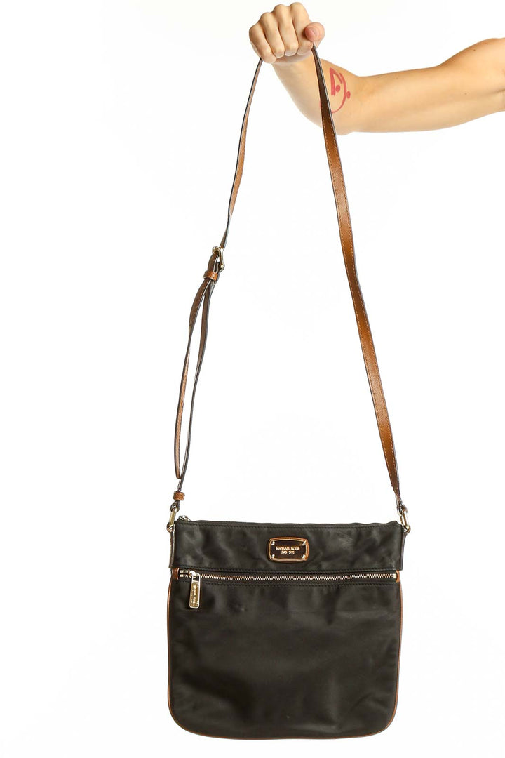 Front view of Michael Kors black nylon crossbody bag with gold-tone hardware