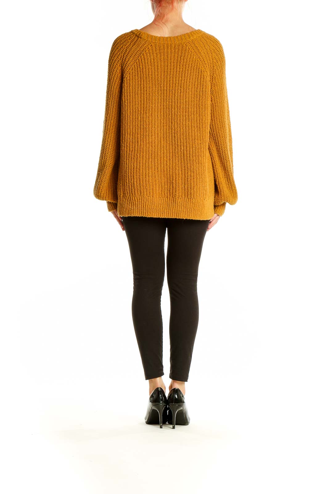 Side view of model wearing Madewell mustard chunky knit oversized sweater with black pants