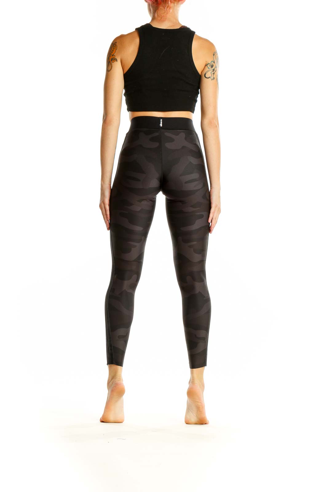 Side view of Ultracor black camo high-waist leggings with black crop top on model