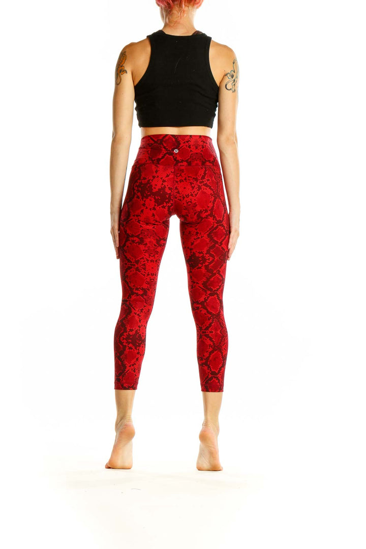 Side view of woman wearing red snake print capri leggings from Lululemon