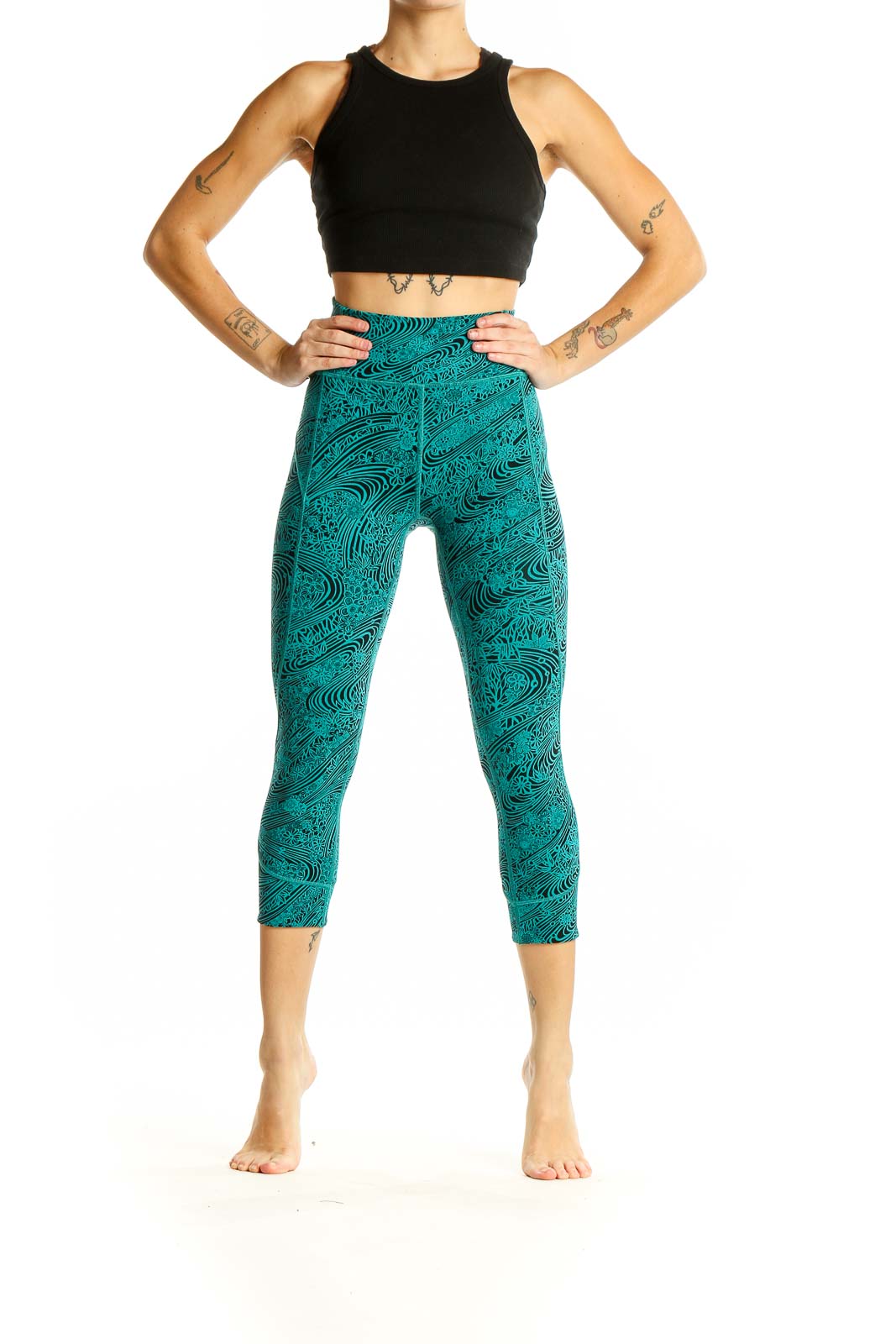 Front view of teal Lululemon capri leggings with black swirl pattern