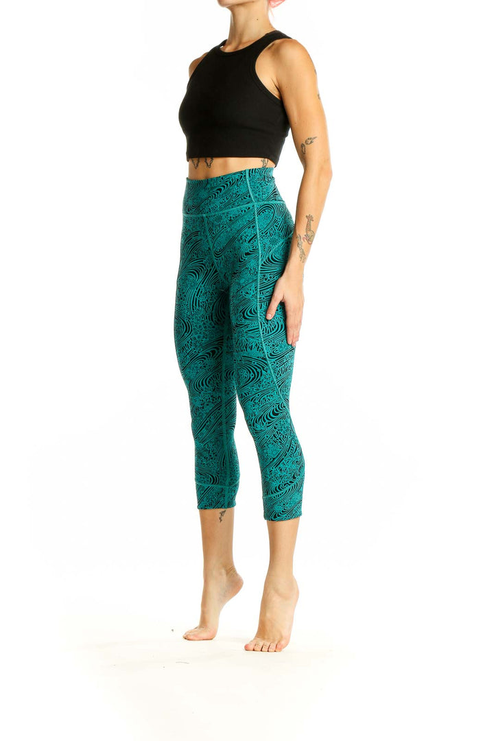 Front view of teal Lululemon capri leggings with black swirl pattern