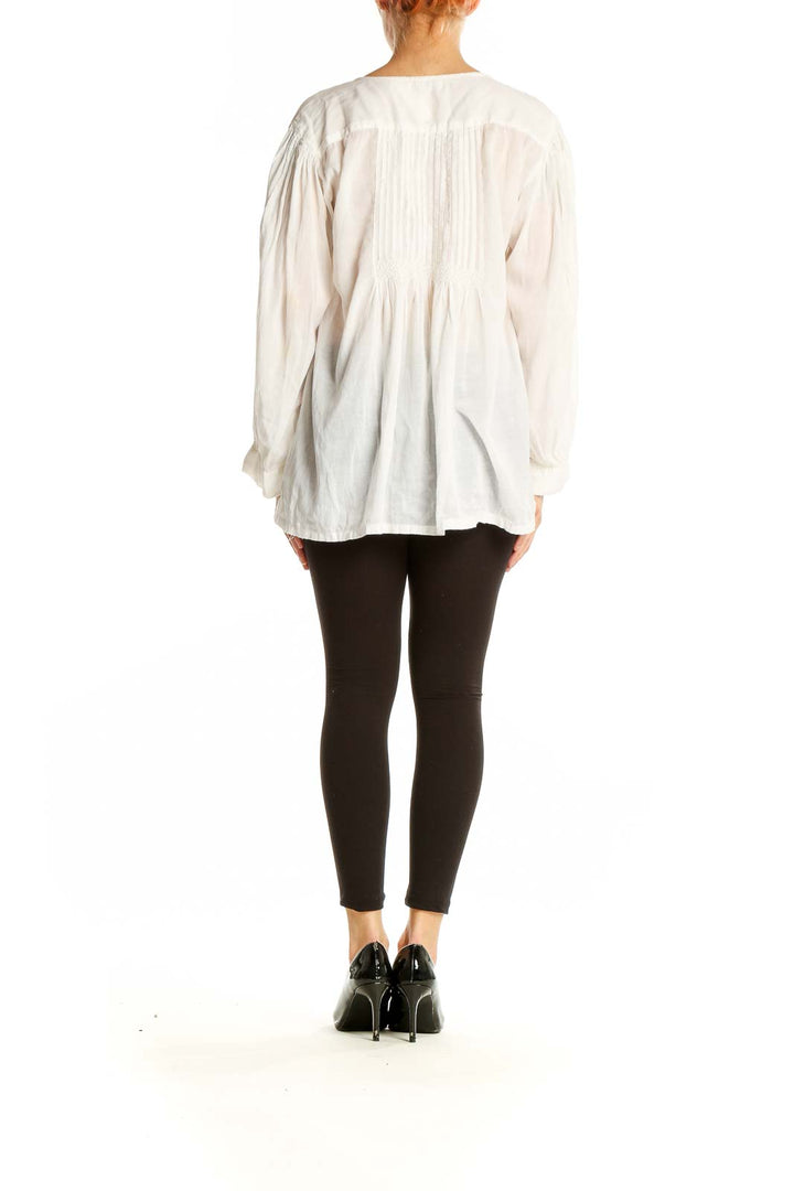 Side view of white pintuck blouse showing billowy sleeves