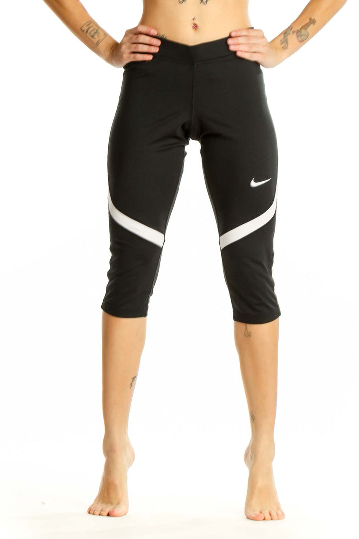 Front view of black Nike capri leggings with white stripe