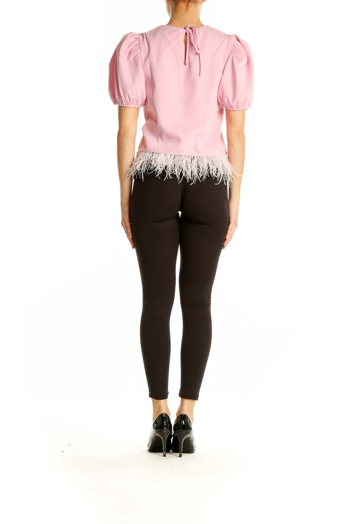 Side view of pink puff-sleeve top with feather trim by English Factory