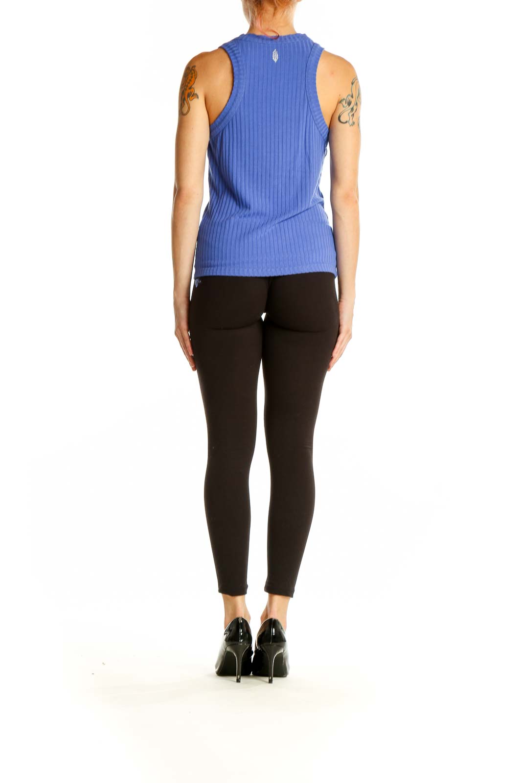 Side view of woman wearing blue ribbed athletic tank top with black leggings