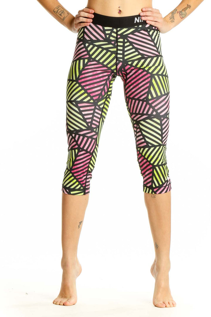 Front view of Nike Pro geometric print capri leggings in pink, yellow, and black