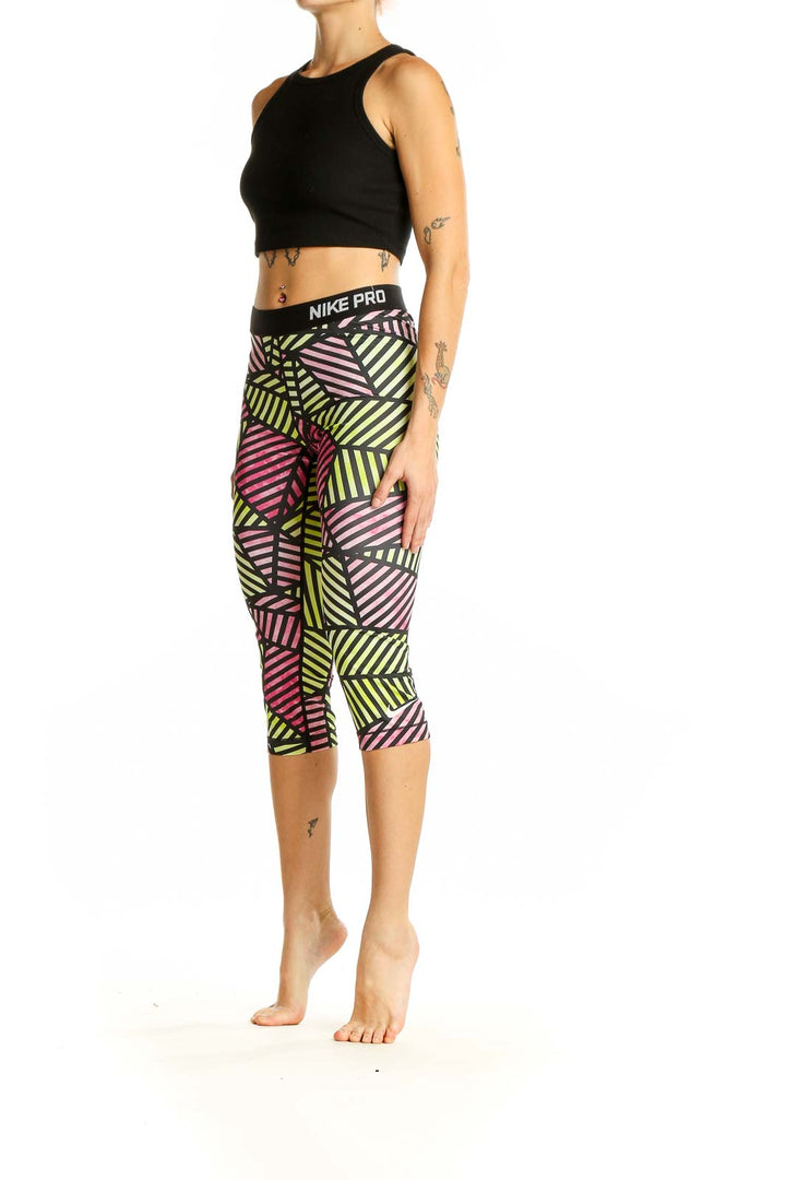 Front view of Nike Pro geometric print capri leggings in pink, yellow, and black