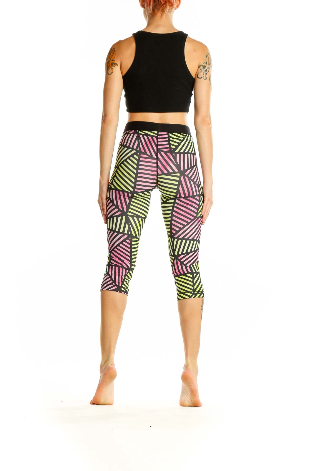 Side view of woman wearing Nike Pro geometric print capri leggings with black crop top