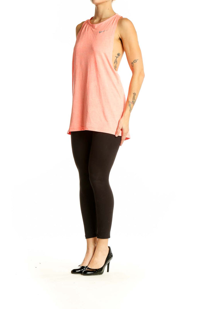 Front view of coral Nike performance tank top on model