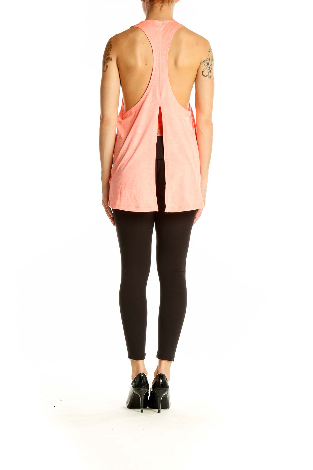 Side view of coral Nike performance tank top on model with black leggings