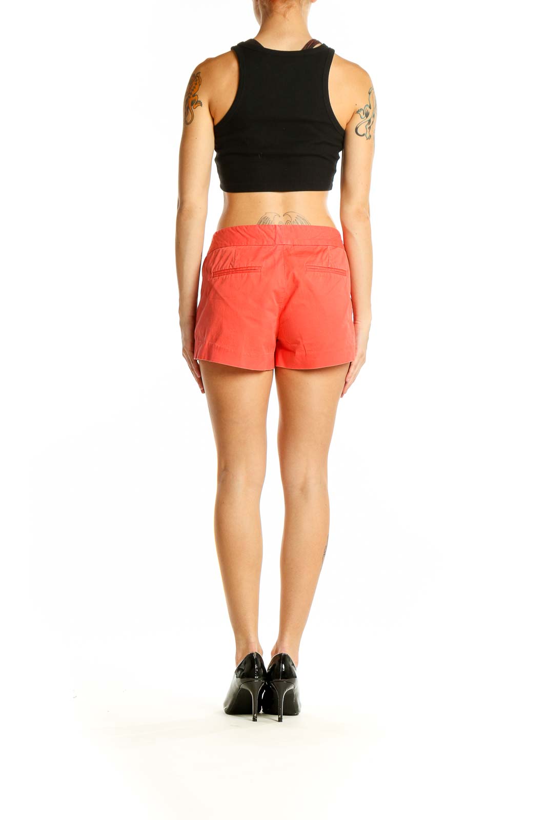 Side view of model wearing coral J.Crew shorts with black top