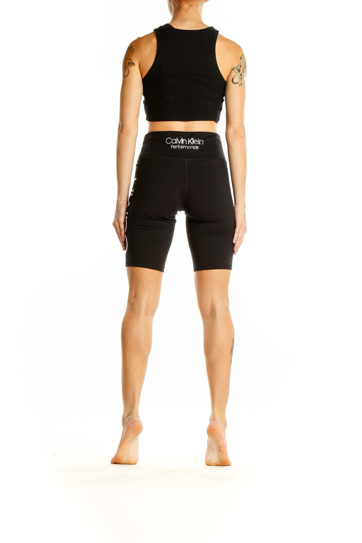 Side view of woman wearing black Calvin Klein Performance bike shorts and matching top