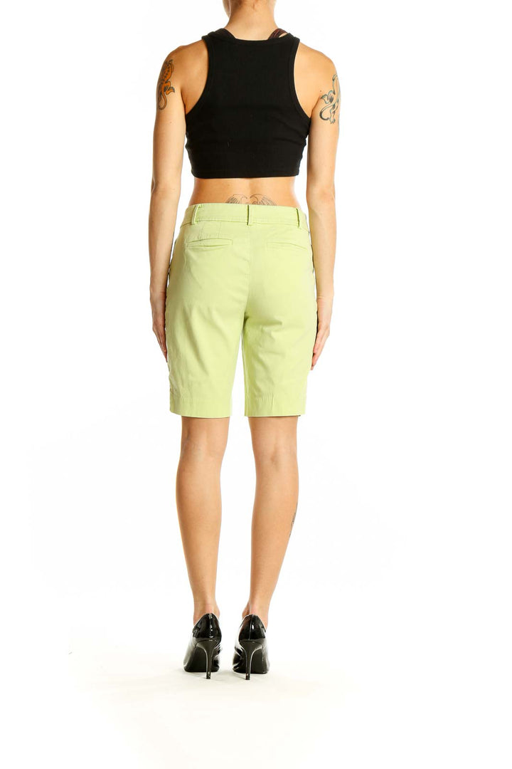 Side view of woman wearing lime green Talbots Bermuda shorts with black top