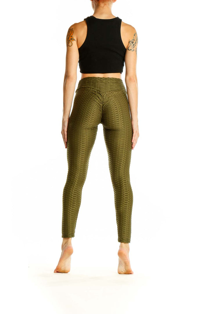 Side view of woman wearing olive textured high-waist activewear leggings by SilkRoll